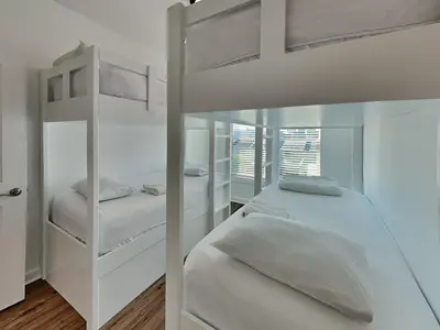 two bunk beds in a bedroom with white walls at Sunset on Snapper C in Panama City Beach