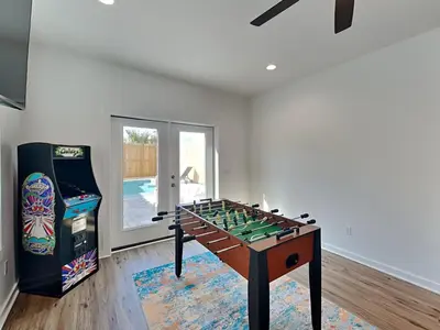 a living room with a foosball table and a video game at Sunset on Snapper C in Panama City Beach