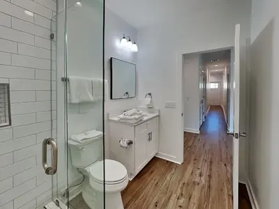 a bathroom with a toilet and a glass shower at Sunset on Snapper C in Panama City Beach