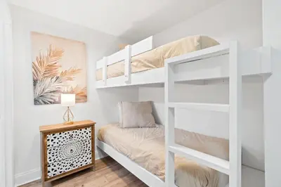 a white bunk bed in a small room with a desk at Relaxing 2nd-Floor Laketown Wharf Condo Overlooking the Lake in Panama City Beach