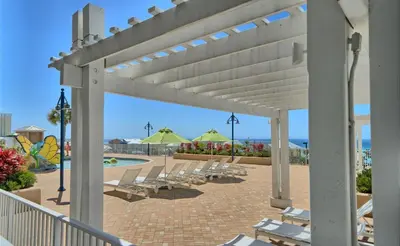a row of lounge chairs on a patio with a pool at Relaxing 2nd-Floor Laketown Wharf Condo Overlooking the Lake in Panama City Beach
