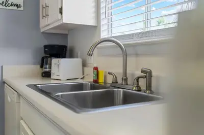 a kitchen counter with a sink and a window at Walk to Emerald Beach,Cozy Coastal Getaway in Panama City Beach