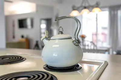 a white tea kettle sitting on top of a stove at Walk to Emerald Beach,Cozy Coastal Getaway in Panama City Beach