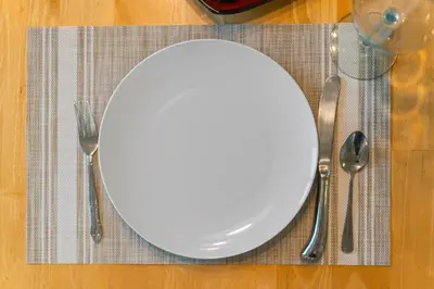 a white plate sitting on top of a table with silverware at Walk to Emerald Beach,Cozy Coastal Getaway in Panama City Beach