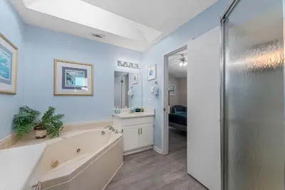 a large bathroom with a tub and a sink at Walk to Emerald Beach,Cozy Coastal Getaway in Panama City Beach