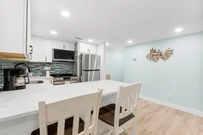 a kitchen with white cabinets and a white counter top at Charming Beachfront Condo with Stunning Views in Panama City Beach