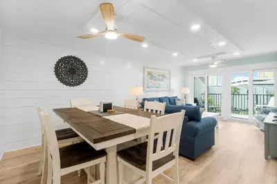 a dining room with a table and a blue couch at Charming Beachfront Condo with Stunning Views in Panama City Beach