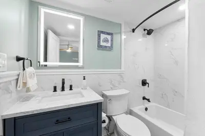 a bathroom with a sink and a toilet and a mirror at Charming Beachfront Condo with Stunning Views in Panama City Beach