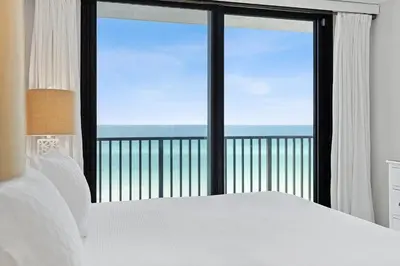 a bedroom with a bed and a view of the ocean at Book Me Baby! License to Chill One Seagrove Place in Seagrove Beach