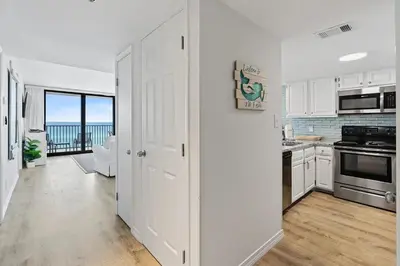 a kitchen with white cabinets and a view of the ocean at Book Me Baby! License to Chill One Seagrove Place in Seagrove Beach