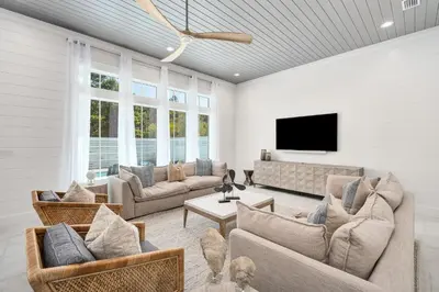 a living room with couches and a flat screen tv at Oz by The Sea in Inlet Beach