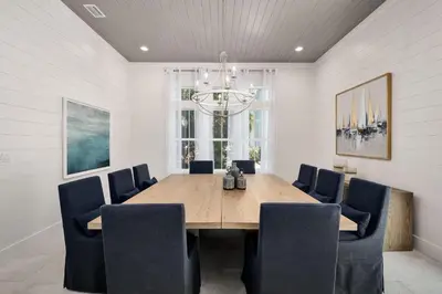 a dining room with a wooden table and chairs at Oz by The Sea in Inlet Beach