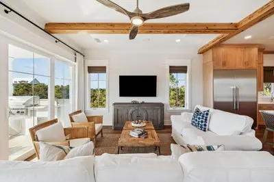 a living room with white furniture and a flat screen tv at Crabstar in Inlet Beach