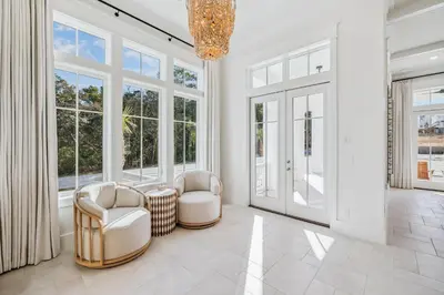 a living room with two chairs and windows at Crabstar in Inlet Beach