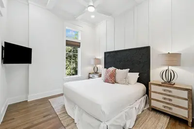 a white bedroom with a bed and a window at Crabstar in Inlet Beach