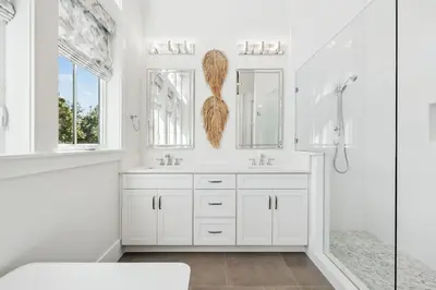 a white bathroom with two sinks and a shower at Crabstar in Inlet Beach
