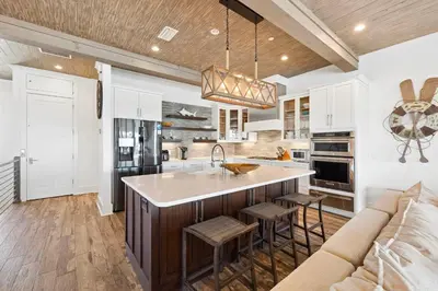 a kitchen with white cabinets and a large island at Emerald Breeze in Inlet Beach