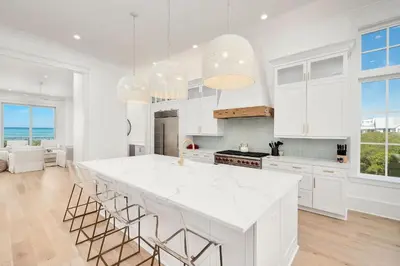 a kitchen with white cabinets and a large island at Marisol 30A in Inlet Beach