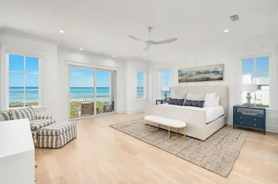 a bedroom with a bed and a living room with the ocean at Marisol 30A in Inlet Beach