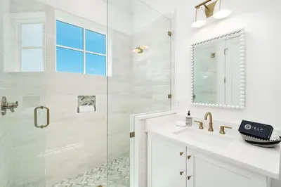 a white bathroom with a shower and a sink at Marisol 30A in Inlet Beach