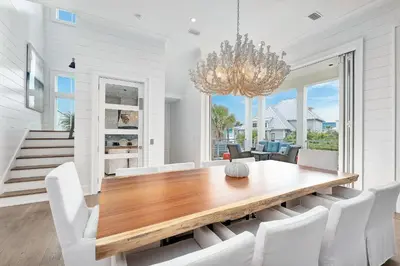 a dining room with a wooden table and white chairs at Sea Turtle Retreat in Seagrove Beach