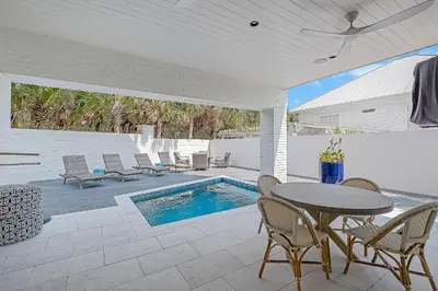 a patio with a table and chairs and a swimming pool at Sea Turtle Retreat in Seagrove Beach