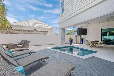 a patio with chairs and a swimming pool at Sea Turtle Retreat in Seagrove Beach