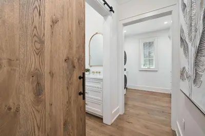 a bathroom with a wooden door and a mirror at Sea Turtle Retreat in Seagrove Beach