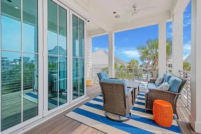 a porch with two chairs and a table at Sea Turtle Retreat in Seagrove Beach