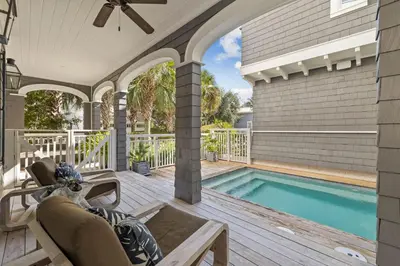 a patio with a swimming pool and a house at Waverly at Watersound in Watersound Beach