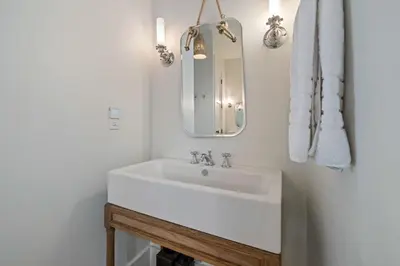 a bathroom with a white sink and a mirror at Waverly at Watersound in Watersound Beach