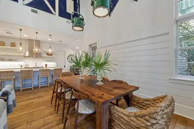 a kitchen and dining room with a wooden table and chairs at Waverly at Watersound in Watersound Beach