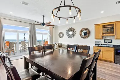 a kitchen and dining room with a table and chairs at Southern Exposure Beach Home in Panama City Beach