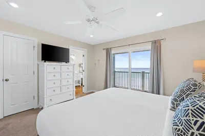 a bedroom with a bed and a tv and a window at Southern Exposure Beach Home in Panama City Beach