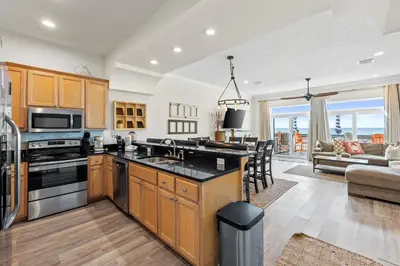 a kitchen and living room with a view of the ocean at Southern Exposure Beach Home in Panama City Beach