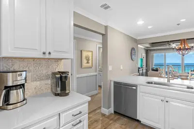 a kitchen with white cabinets and a view of the ocean at High Pointe Resort Unit 44E in Inlet Beach