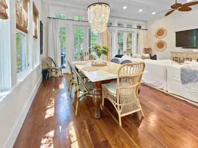a dining room with a table and chairs and a couch at 116 Surfer Ln l Resort Style Community Pool l Walk to Rosemary Beach in Rosemary Beach