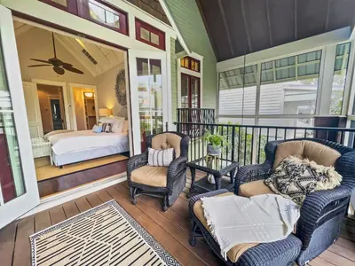 a porch with chairs and a bed in a bedroom at 116 Surfer Ln l Resort Style Community Pool l Walk to Rosemary Beach in Rosemary Beach