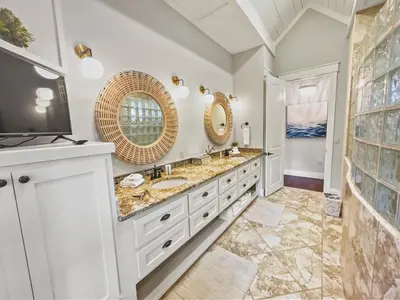 a bathroom with two sinks and a flat screen tv at 116 Surfer Ln l Resort Style Community Pool l Walk to Rosemary Beach in Rosemary Beach