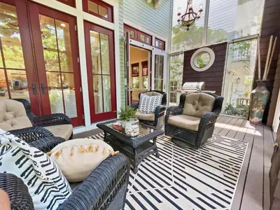 a porch with couches and chairs on a house at 116 Surfer Ln l Resort Style Community Pool l Walk to Rosemary Beach in Rosemary Beach