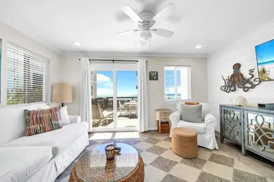 a living room with a white couch and a tv at Book Me Baby! You are in Luck! I Am Gulf Front! in Santa Rosa Beach