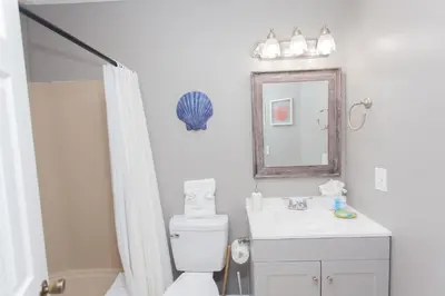 a bathroom with a toilet and a sink and a mirror at 16 Chateau in Panama City Beach