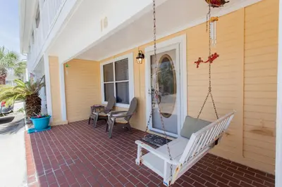 a porch with a swing on a house at 16 Chateau in Panama City Beach