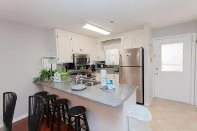 a kitchen with white cabinets and a granite counter top at 16 Chateau in Panama City Beach