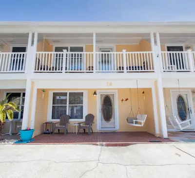 a yellow house with two chairs and a balcony at 16 Chateau in Panama City Beach