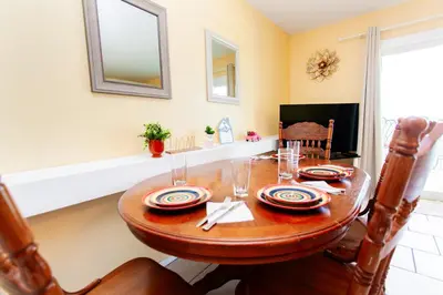 a dining room with a wooden table and chairs at Summit 903 in Panama City Beach