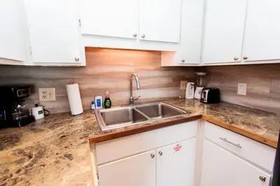 a kitchen with white cabinets and a sink at Summit 903 in Panama City Beach