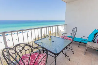 a table and chairs on a balcony with the beach at Summit 903 in Panama City Beach