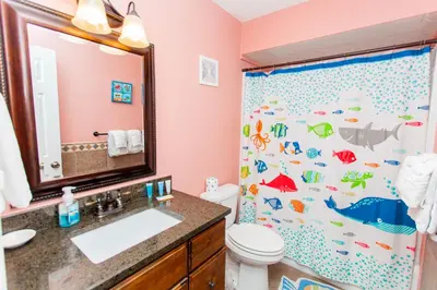 a bathroom with a shower curtain with fish on it at Regency 1023 in Panama City Beach