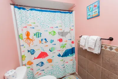 a bathroom with a shower curtain with fish on it at Regency 1023 in Panama City Beach